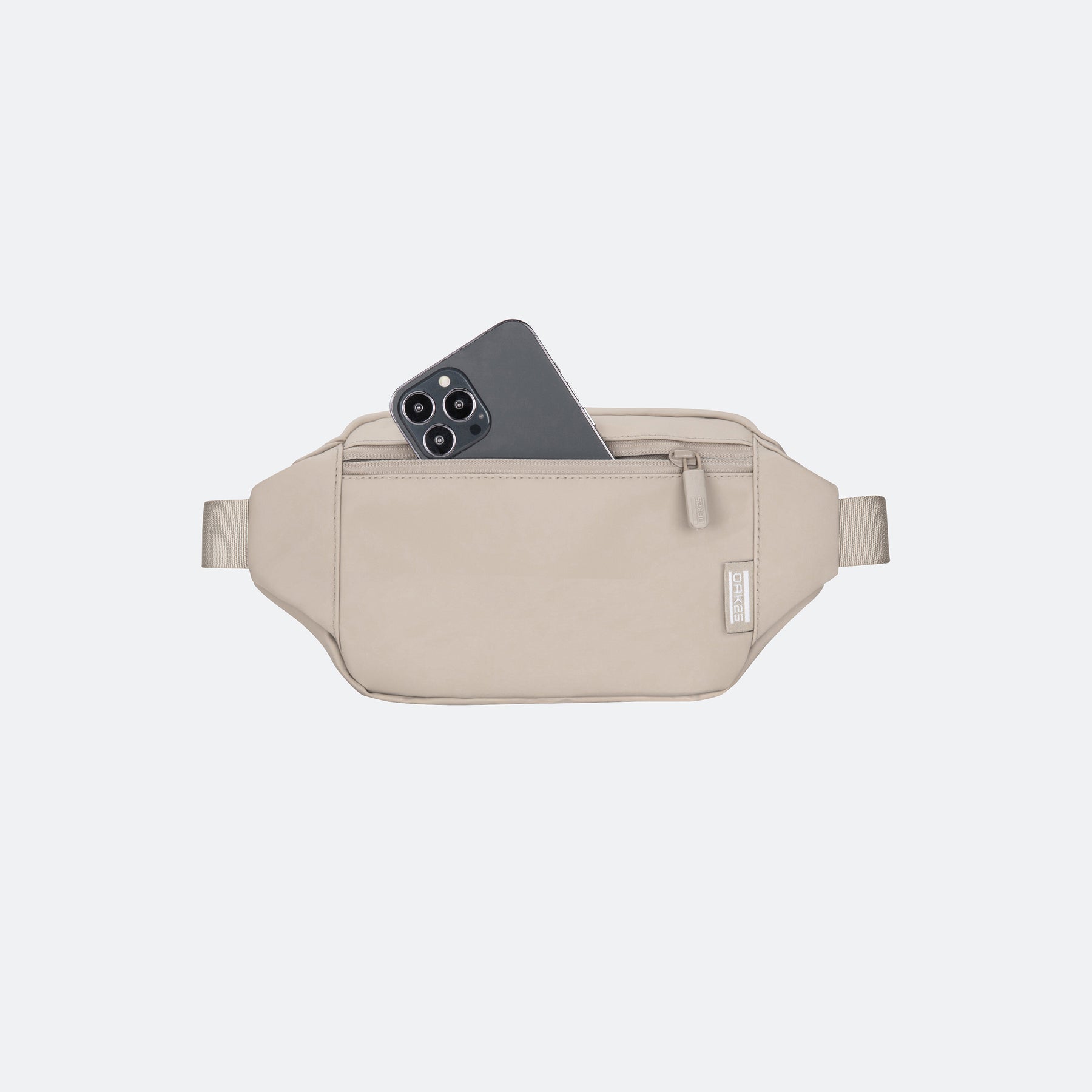 Beige OAK25 Carry All Sling Tasche mit sichtbarem Smartphone in der Reißverschlusstasche