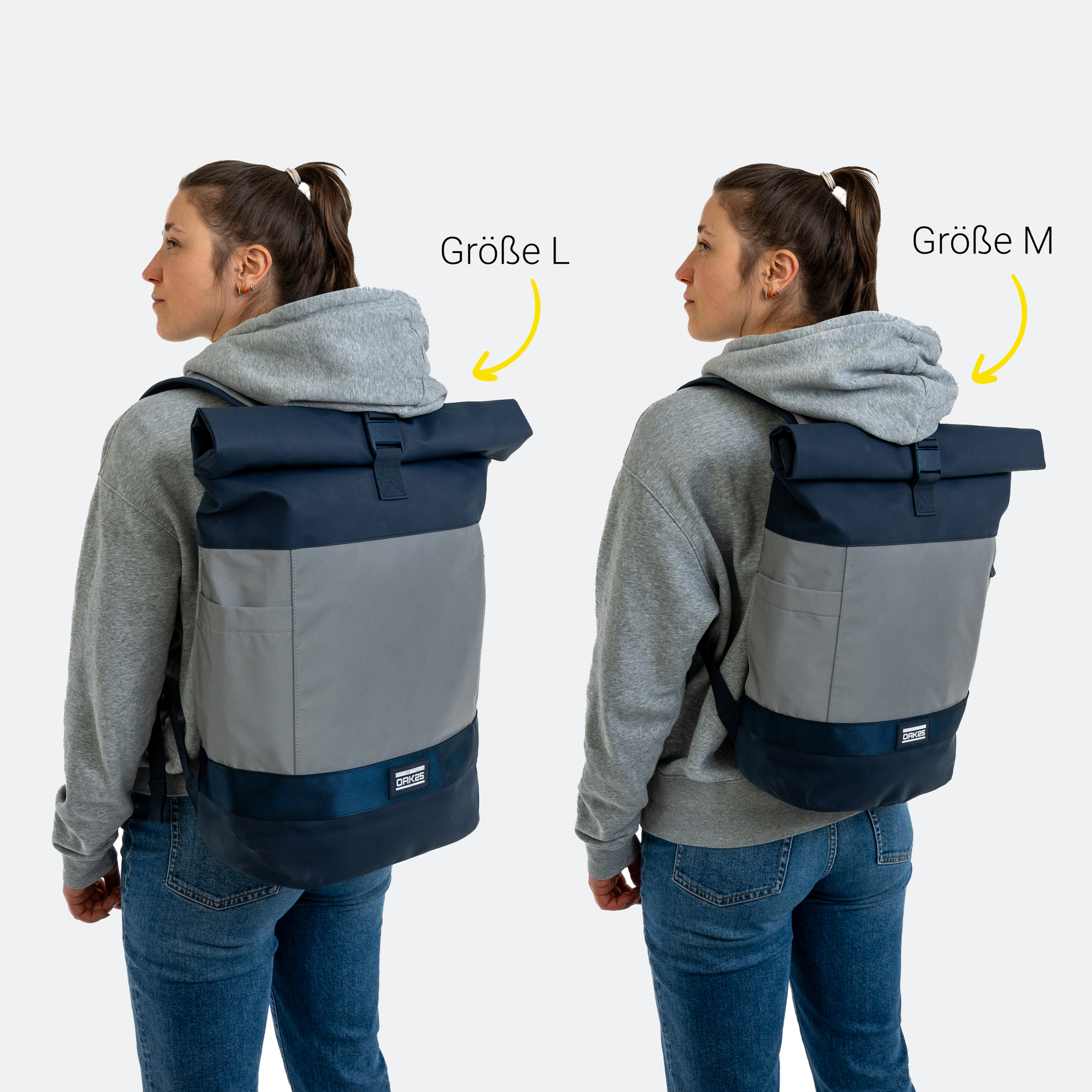 Frau von hinten mit grauer Kapuzenjacke und dunkelblau-grauem Rolltop-Rucksack in den Größen L und M
