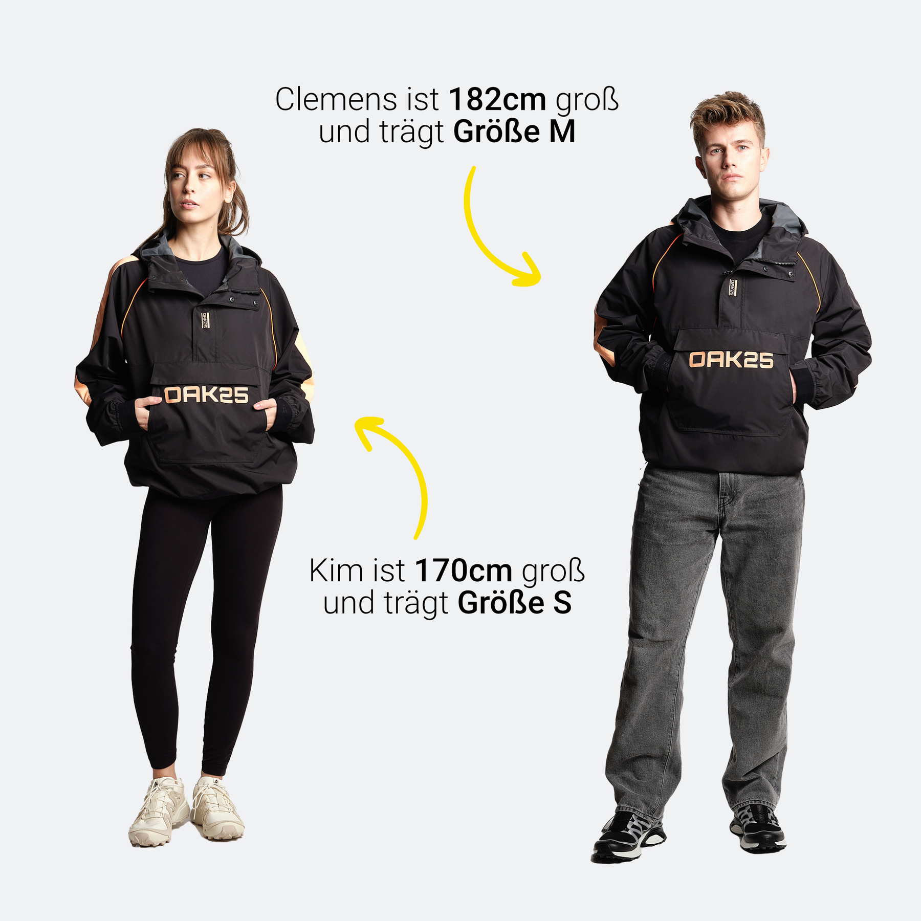 Zwei Modelle tragen OAK25 Windbreaker in Schwarz mit Pfirsichakzenten, einer ist 182 cm groß und trägt Größe M, der andere 170 cm groß und trägt Größe S