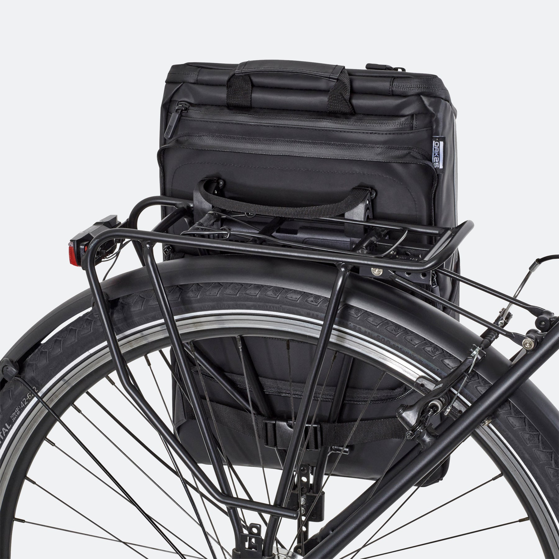 Schwarze 2-in-1 Fahrradtasche von OAK25 an Gepäckträger eines Fahrrads befestigt
