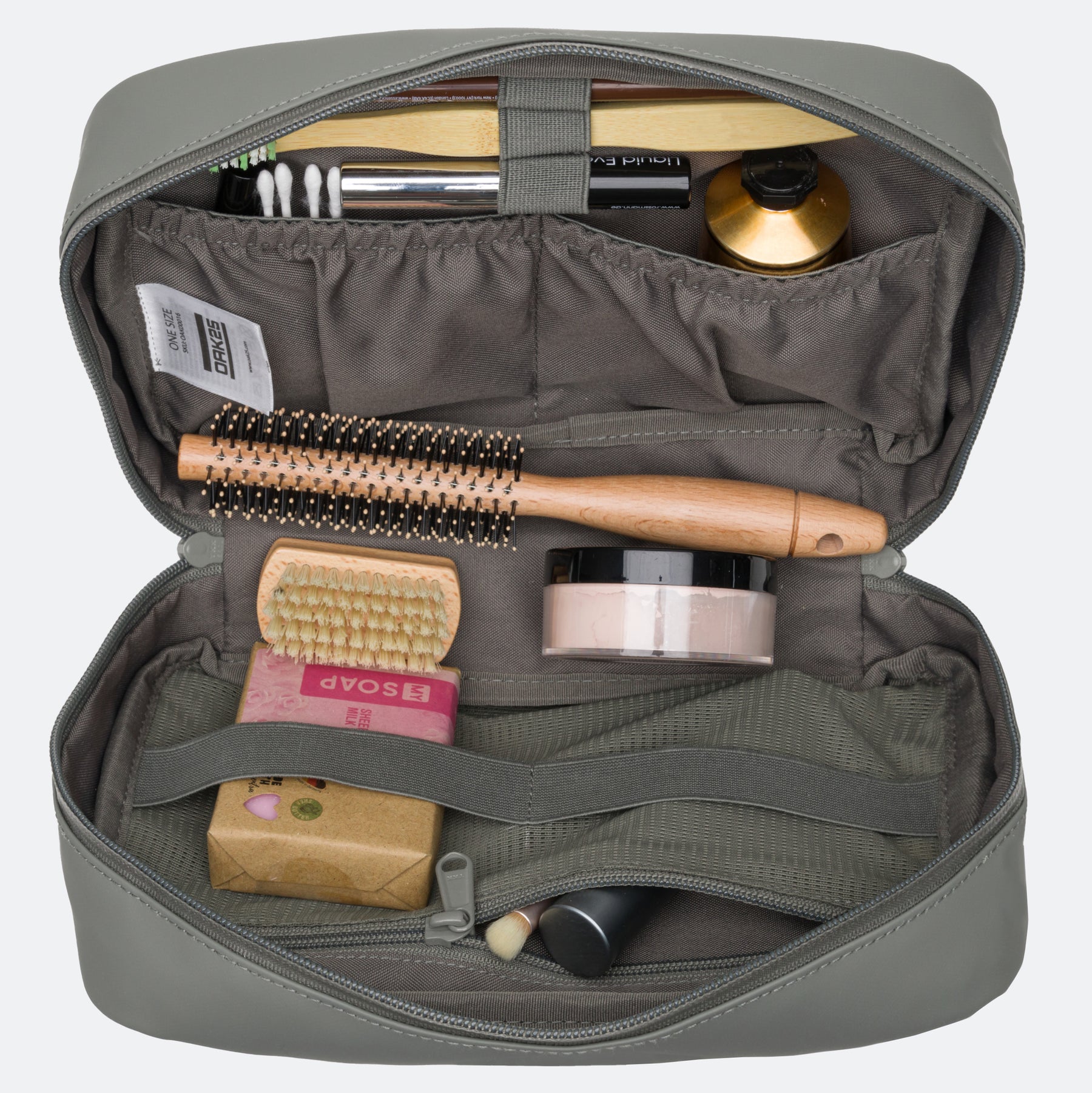 Salbeigrüne wasserabweisende Kulturtasche von OAK25 mit Fächern, gefüllt mit Haarbürste, Seife, Creme und Kosmetikartikeln