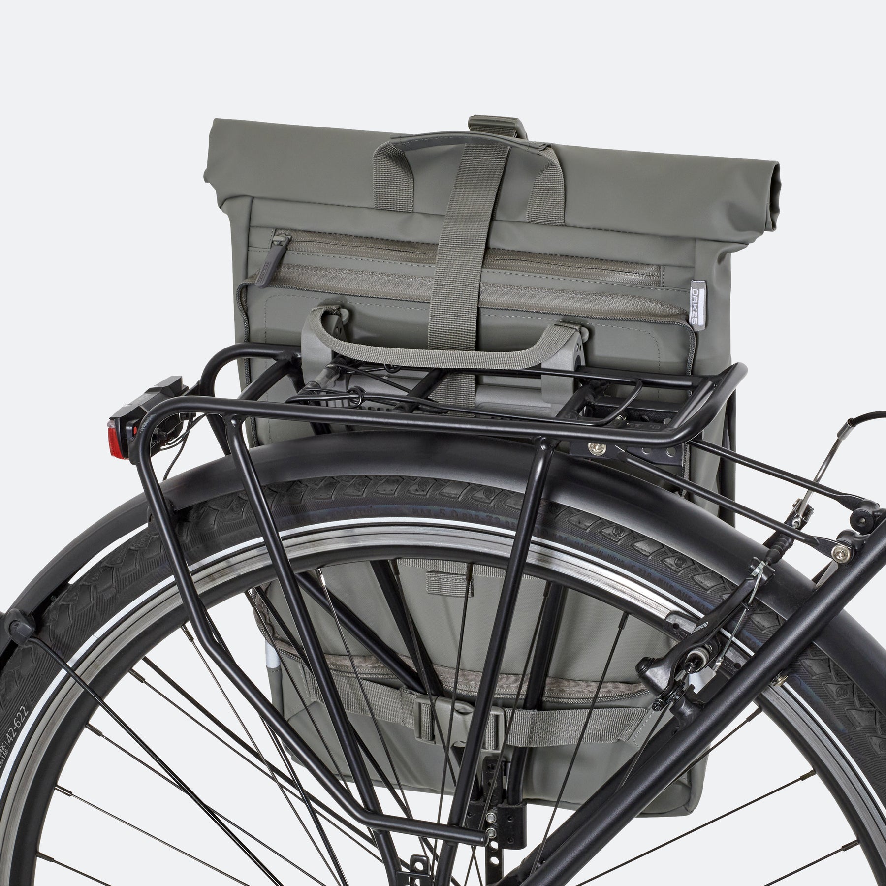 Salbeifarbene OAK25 Everyday Rolltop 2in1 Fahrradtasche am Gepäckträger eines schwarzen Fahrrads