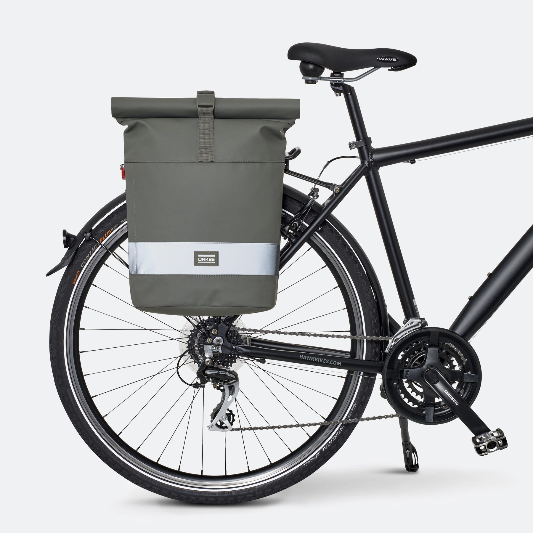 Salbeigrüne OAK25 Everyday Rolltop Fahrradtasche mit reflektierendem Streifen an einem schwarzen Fahrrad befestigt
