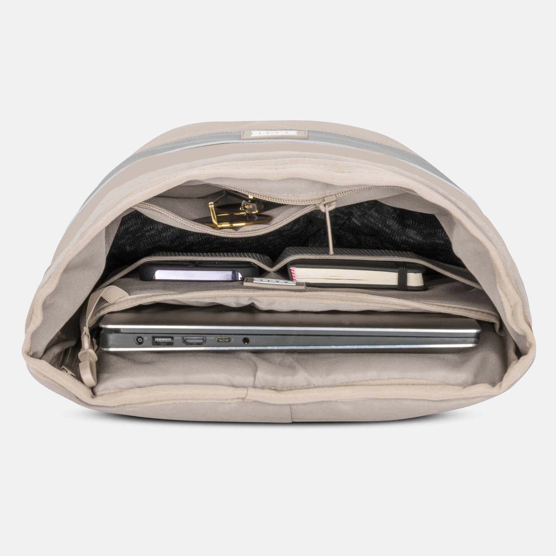 Sandfarbener Rucksack mit geöffnetem Hauptfach, das Laptopfach und Innenfächer mit Laptop, Notizbüchern und anderem Zubehör zeigt