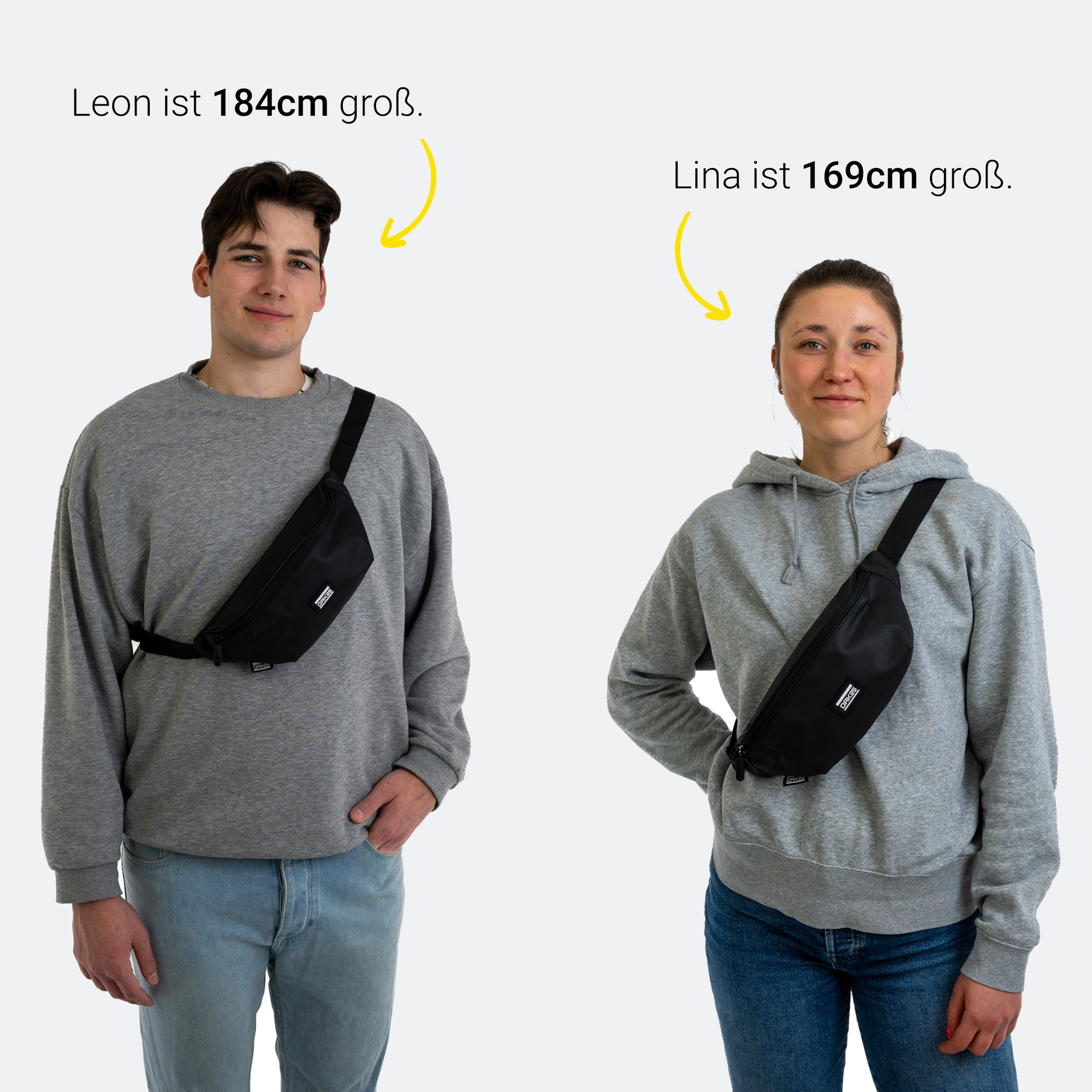 Mann (Leon, 184 cm) und Frau (Lina, 169 cm) tragen schwarze Everyday Sling Taschen quer vor dem Oberkörper