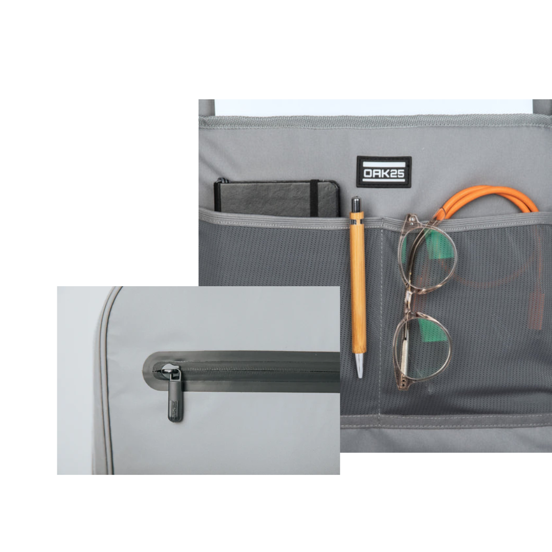 Graue Tasche mit Netzfächern, gefüllt mit Notizbuch, Stift, Brille und Ladekabel, Nahaufnahme eines Reißverschlusses mit OAK25-Branding