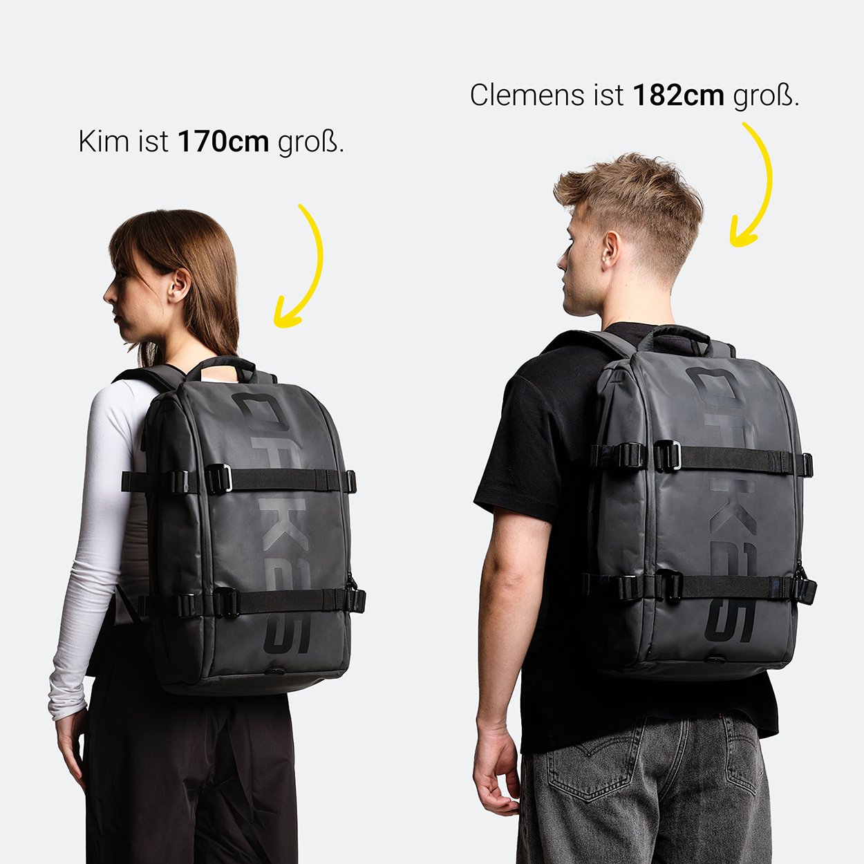 Zwei Personen von hinten tragen schwarze OAK25 Luminite Daybag Rucksäcke, weiblich 170 cm, männlich 182 cm groß