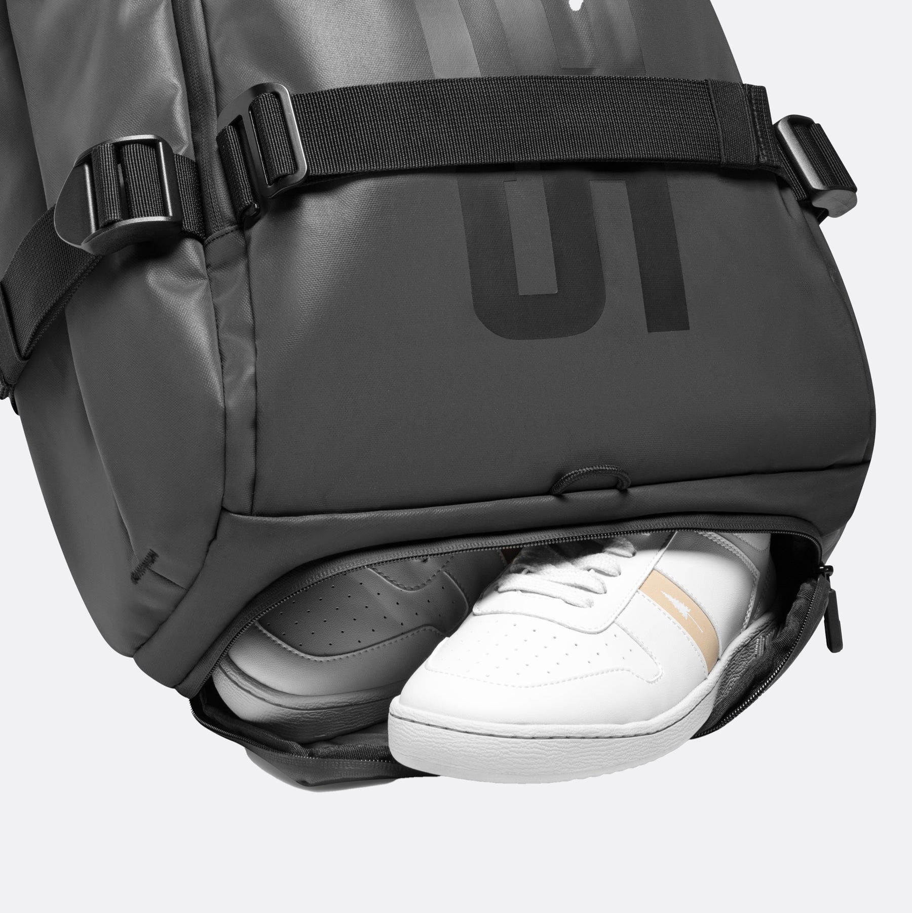 Schwarzer Rucksack mit offenem, separatem Schuhfach, das ein Paar weiße Sneaker enthält